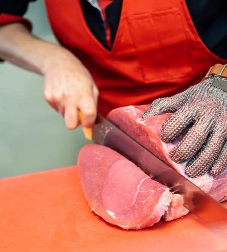 woman-cutting-fresh-meat-butcher-shop-with-metal-safety-mesh-glove